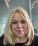 A smiling woman with shoulder length blond hair
